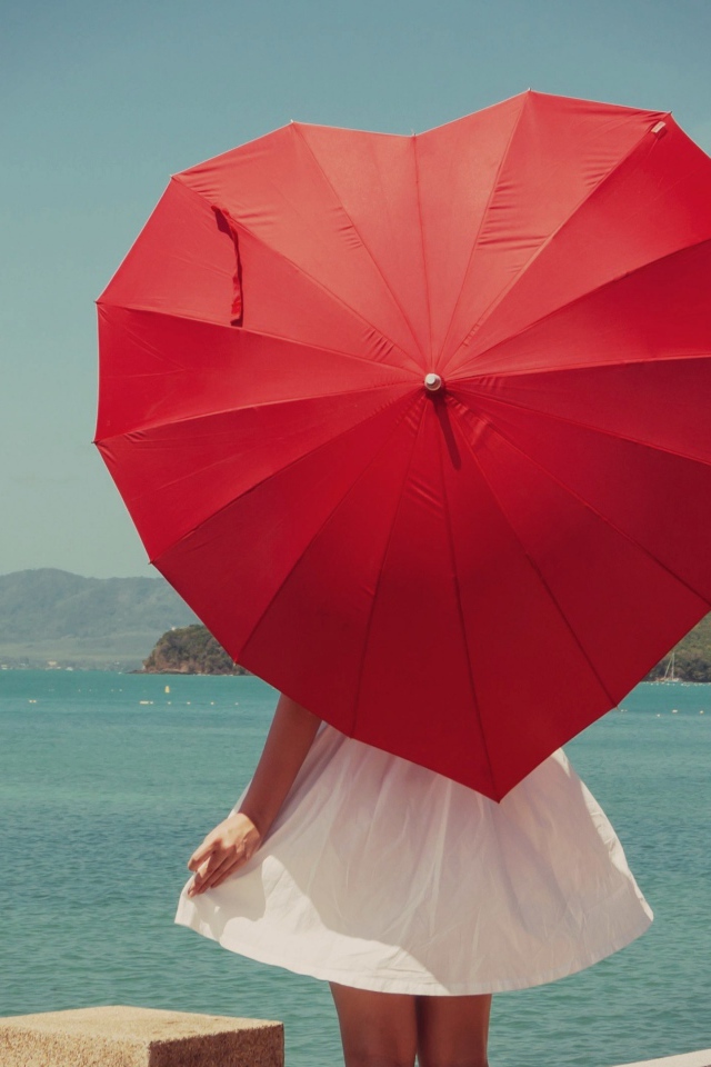 Молодая девушка с красным зонтом в форме сердца