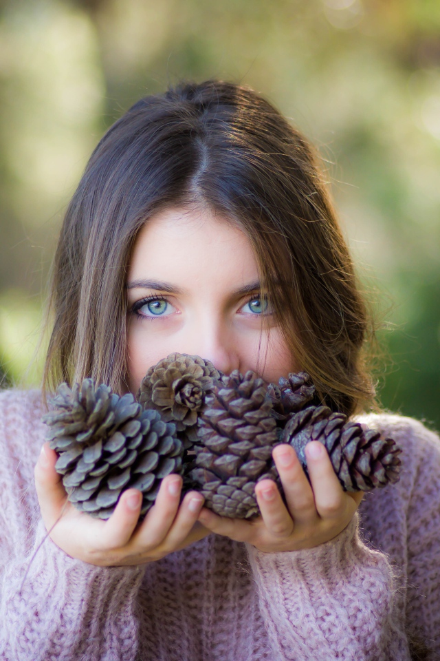 Молодая девушка с шишками в руках