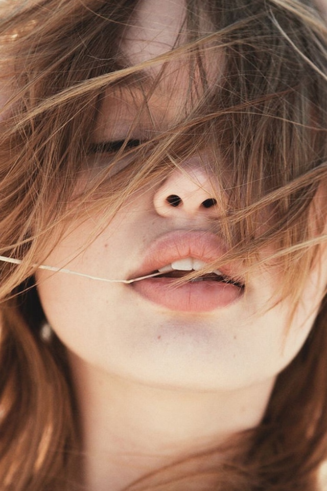 Молодая девушка с распущенными волосами на ветру