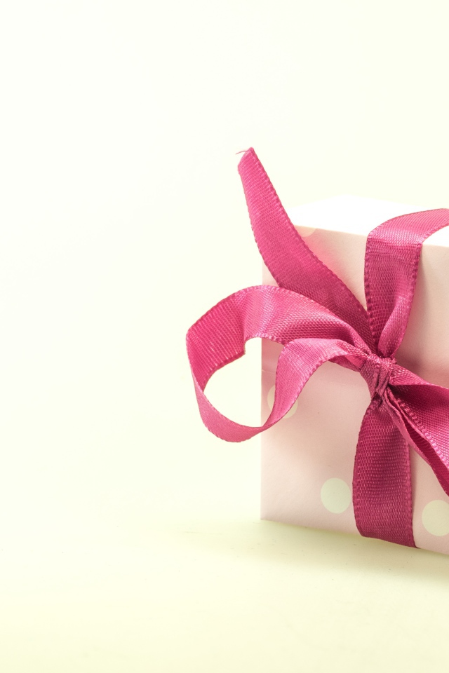Подарочная коробка с розовым бантом на белом фоне