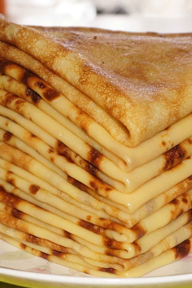 Стопка тонких блинов с ромашкой на Масленицу