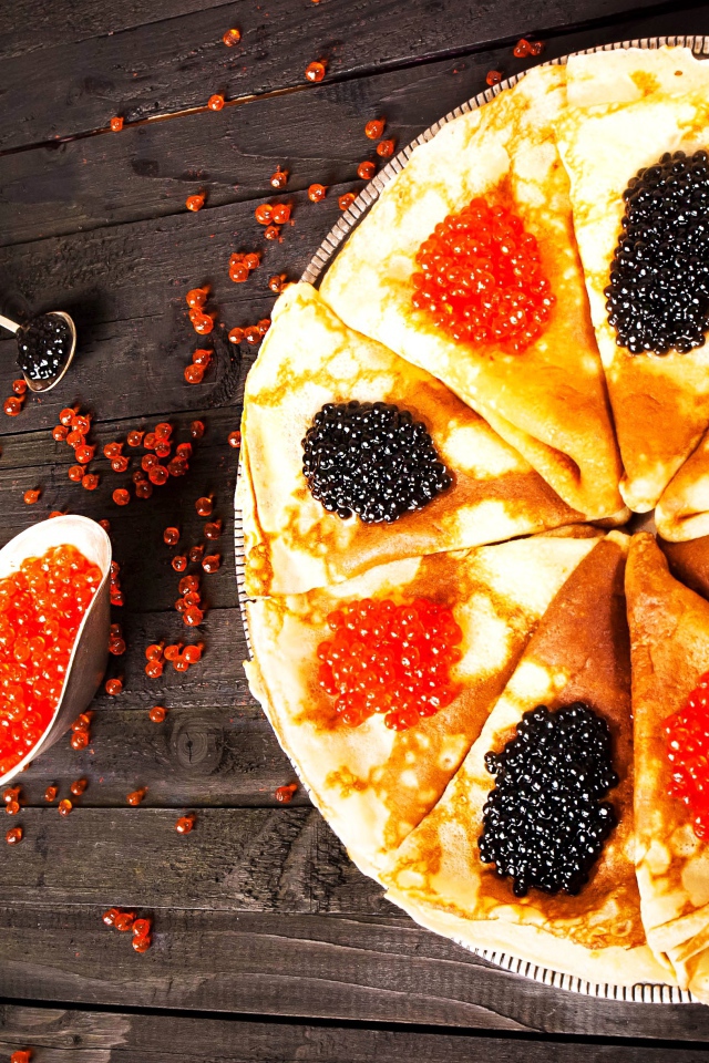 Блины с черной и красной икрой на деревянном столе на Масленицу