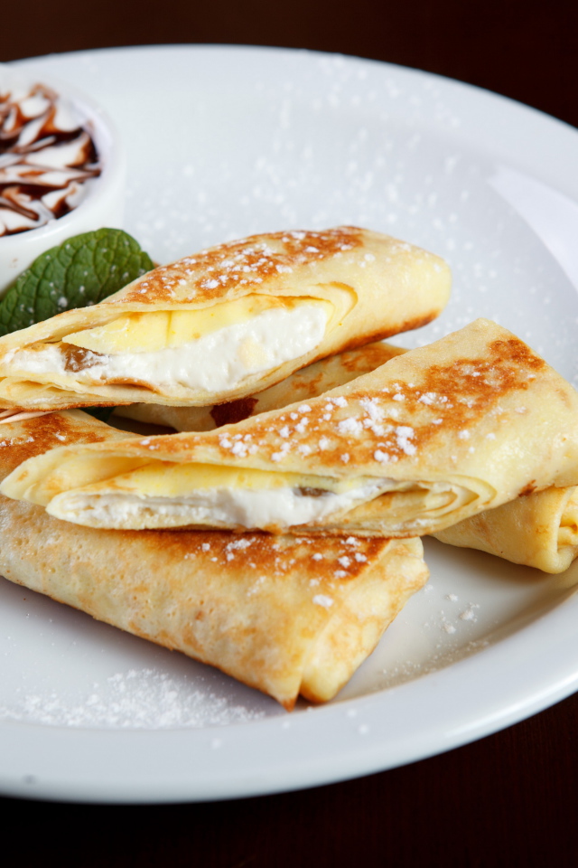 Блины с творогом и сметаной на белой тарелке на Масленицу