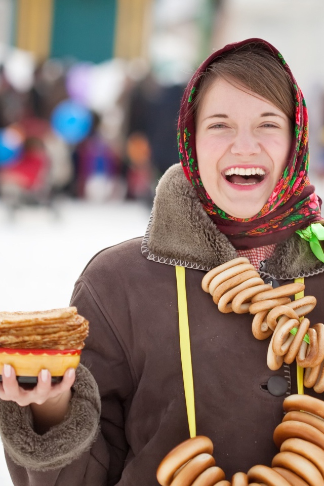 Smiling girl with refreshments for the Maslenitsa holiday 2018