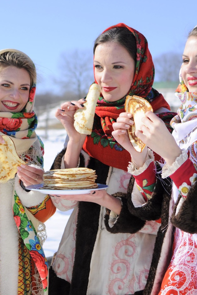 Три молодые красивые девушки с блинами на Масленицу