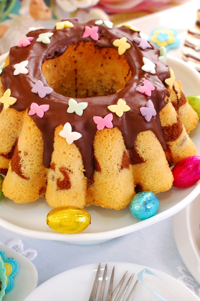 Красивый пасхальный кулич с шоколадом и яйцами на столе к празднику