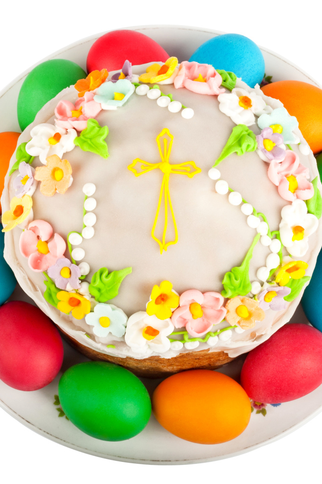 Красивый пасхальный кулич с цветами и разноцветными крашеными яйцами на белом фоне