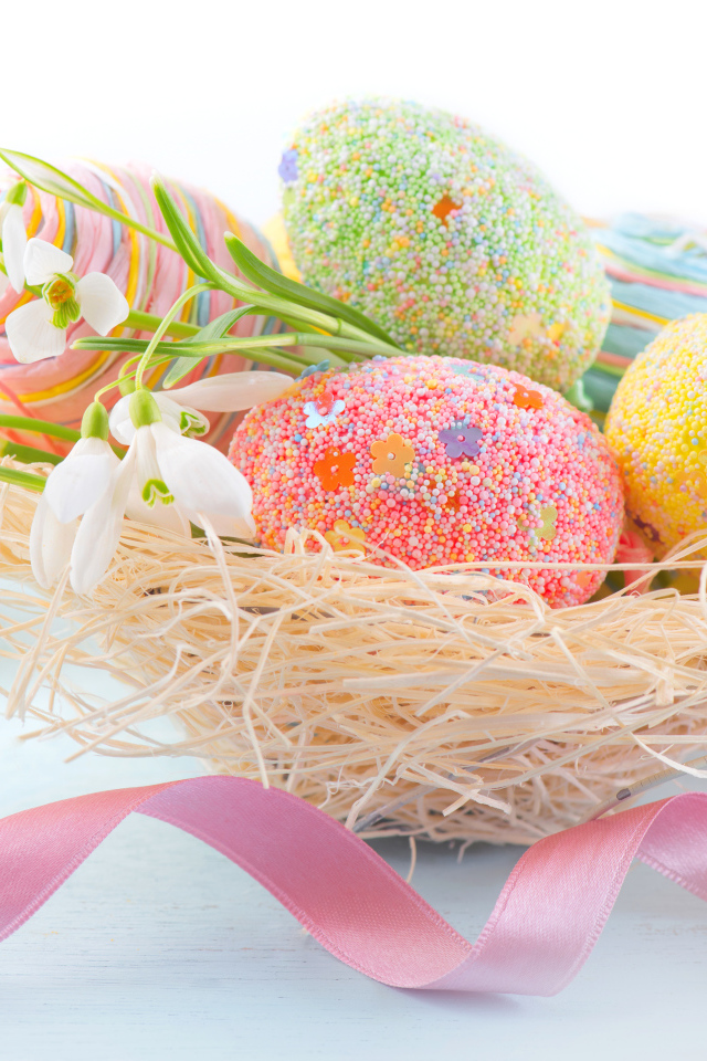 Красивые крашеные  пасхальные яйца с подснежниками на белом фоне