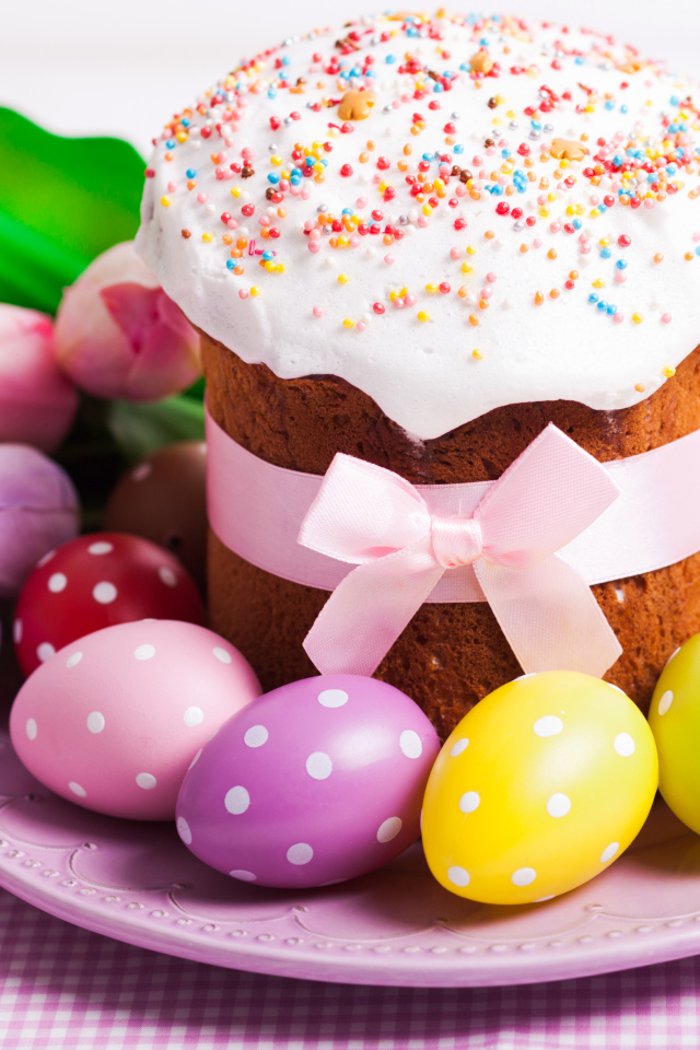 Пасхальный кулич с крашеными яйцами и букетом цветов