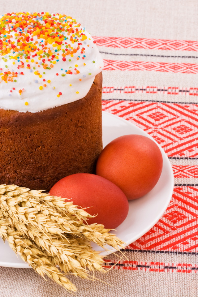 Пасха с крашеными яйцами и колосьями пшеницы на столе с красивой скатертью