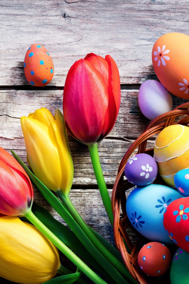 Крашеные яйца на столе с тюльпанами на Пасху