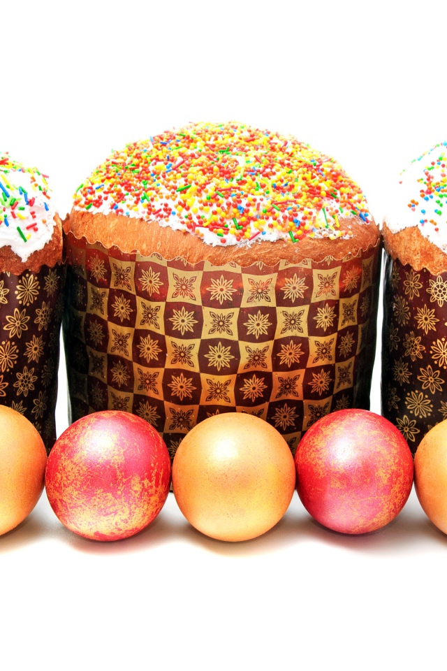 Три пасхальных кулича с крашеными яйцами на белом фоне на праздник Пасха