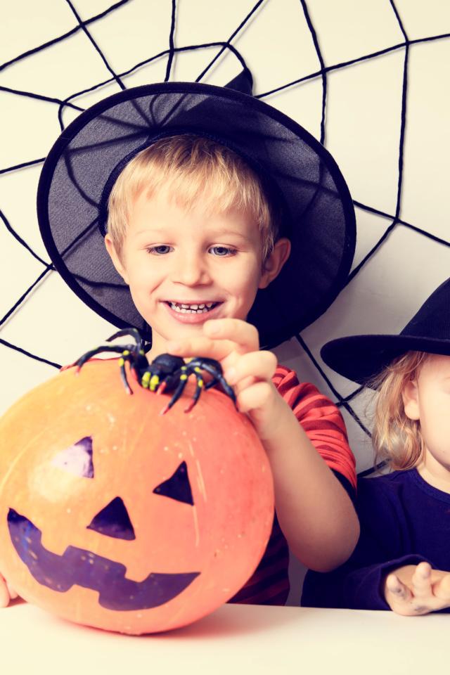 Маленькие мальчик и девочка в костюмах на Хэллоуин