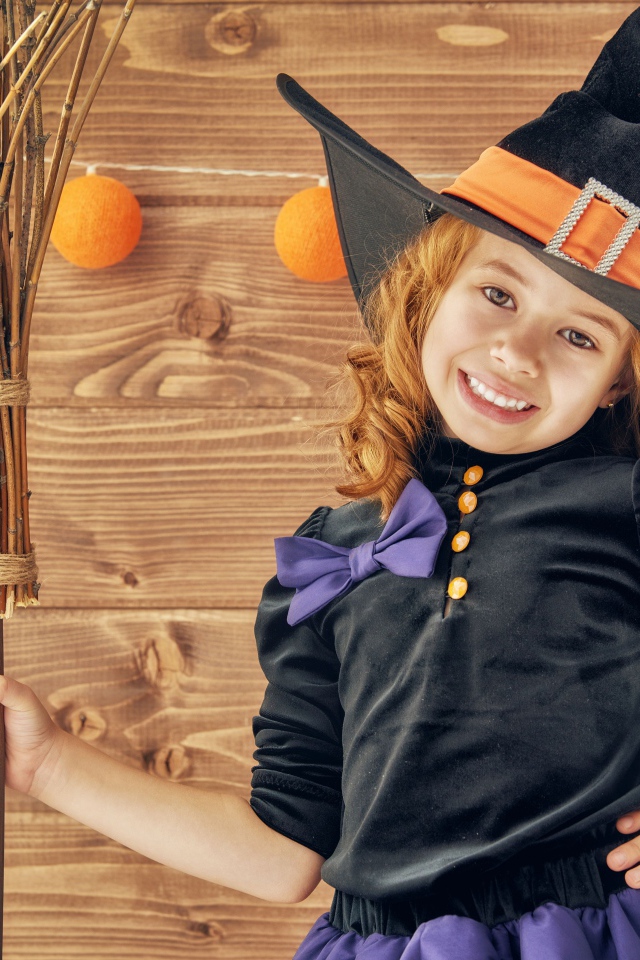 Маленькая девочка в костюме ведьмы на праздник Хэллоуин