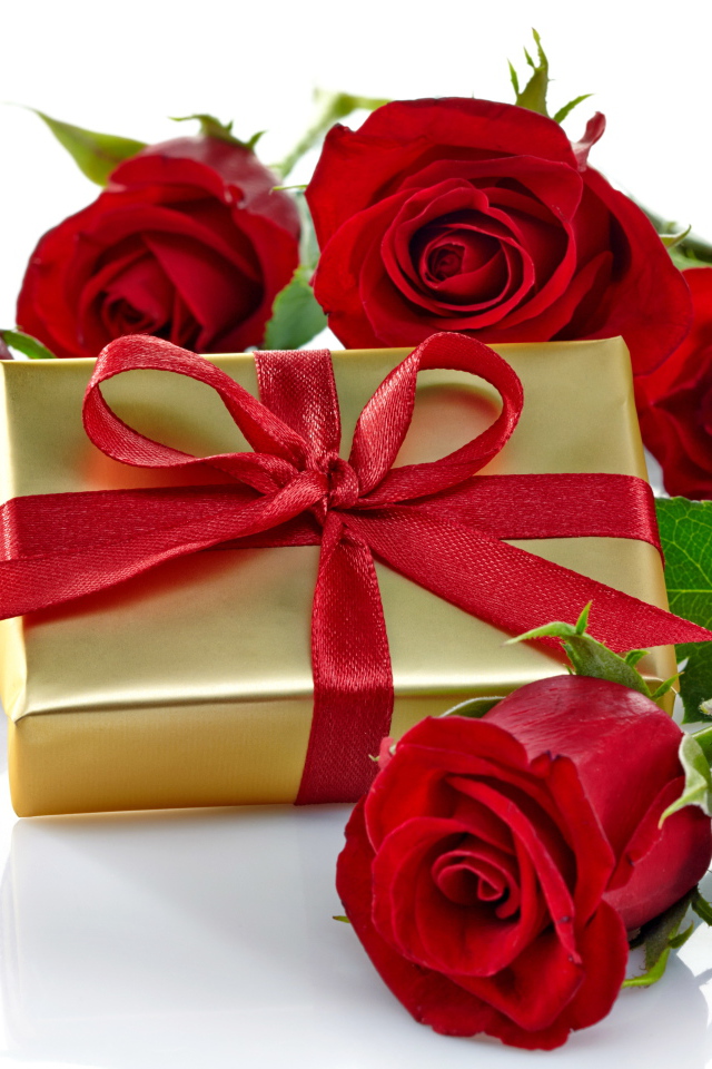 Подарок и букет красных роз на белом фоне к празднику 8 марта