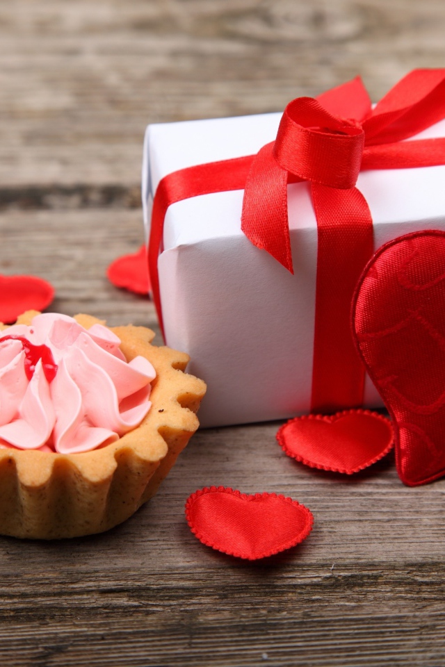 Cake, gift and hearts on a wooden background for Valentine's Day