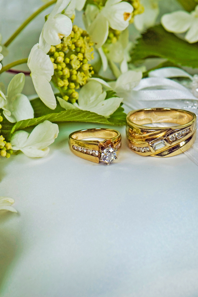 Два обручальных кольца на подушечке обшитой цветами