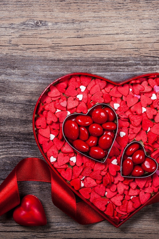 Коробка конфет в форме сердца с красной лентой в подарок