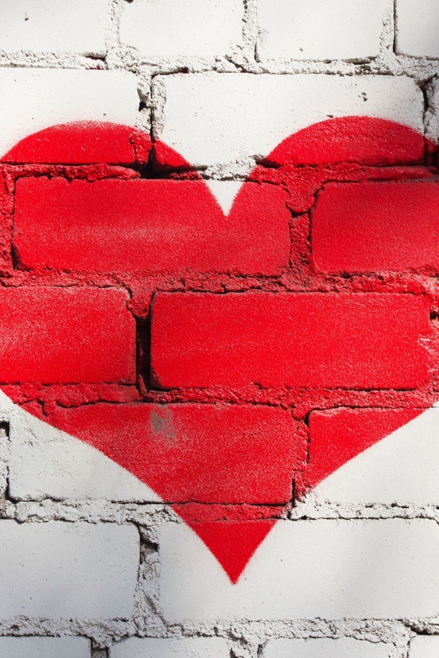 Большое красное сердце нарисовано на кирпичной стене