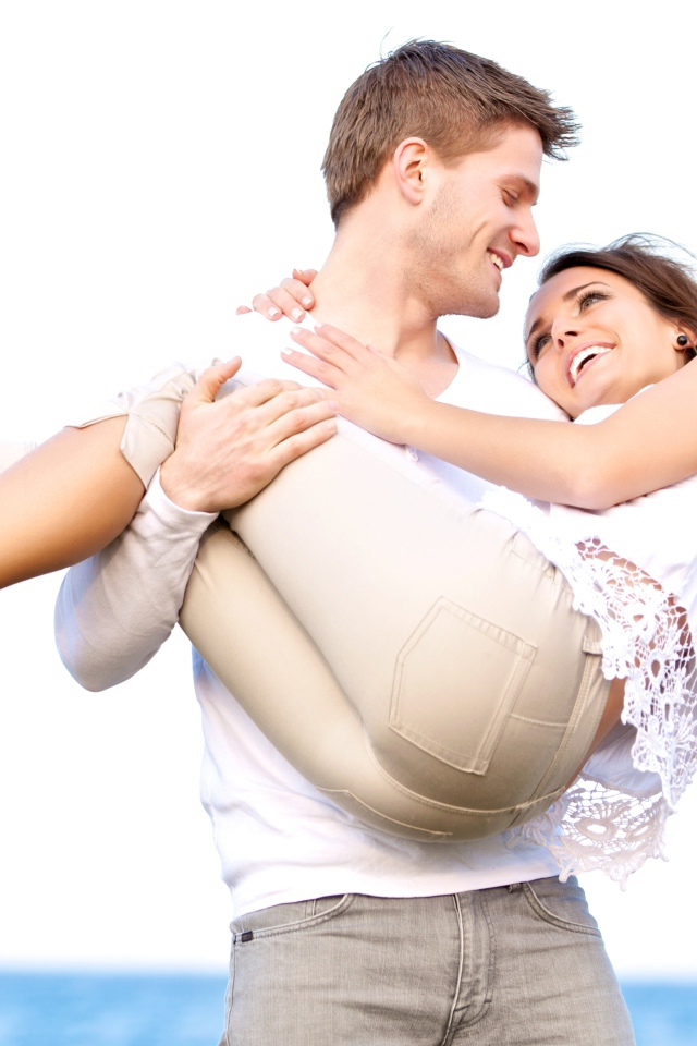 Влюбленный парень держит девушку на руках