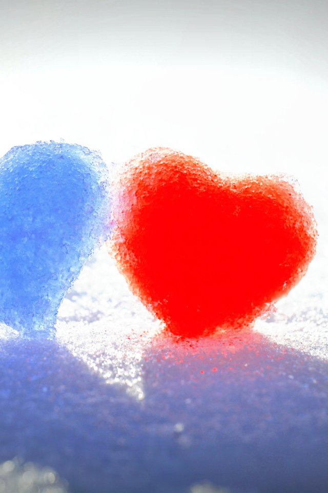 Голубое и красное сердце на белом снегу 