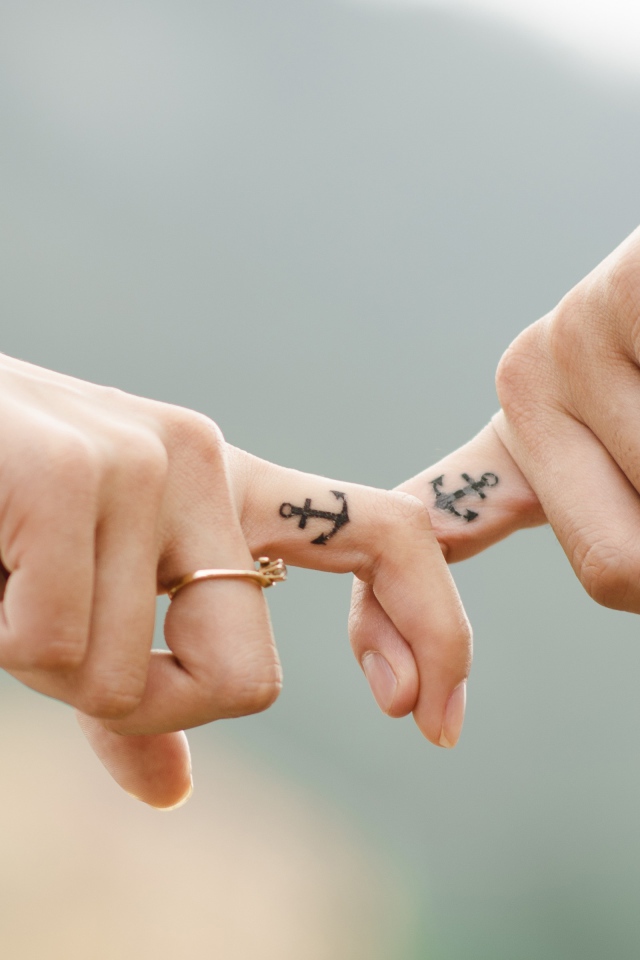 Руки влюбленной пары с татуировками на руках 