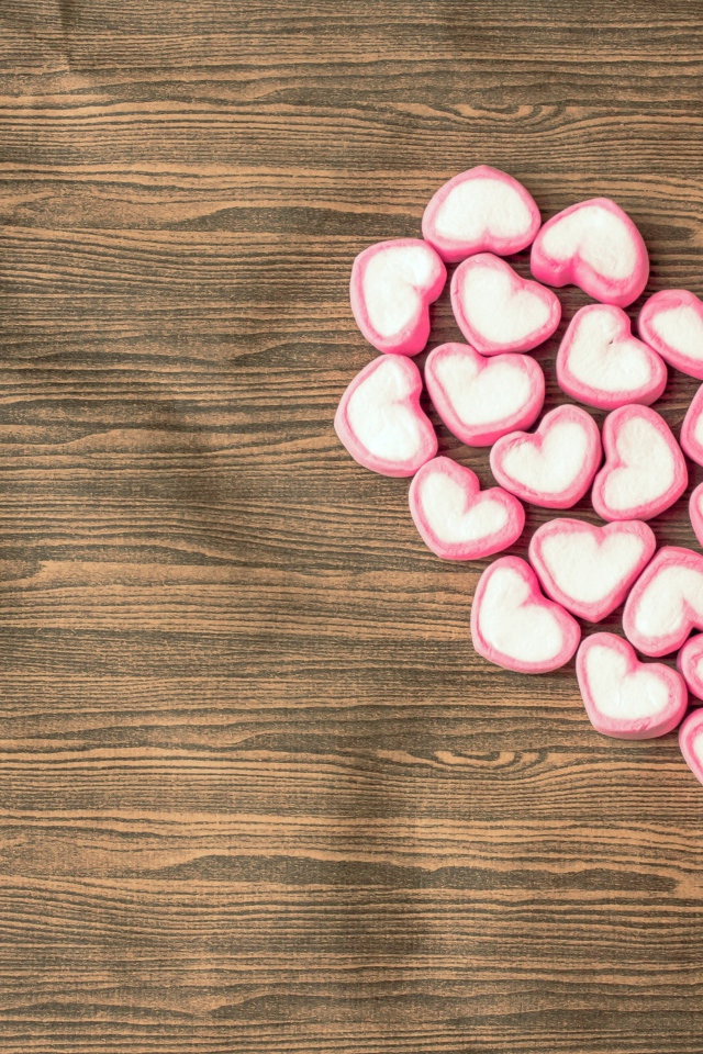 Сердце из конфет в форме сердца на деревянном столе