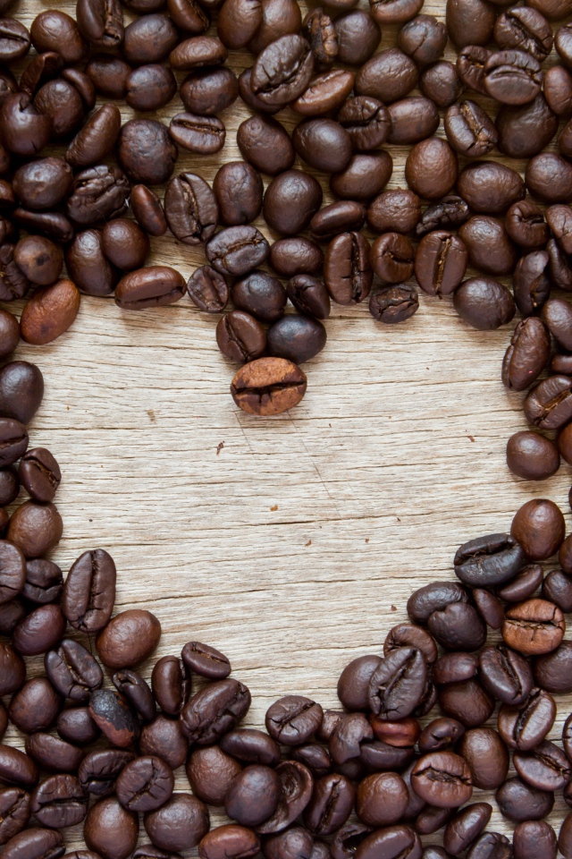 Сердце из кофейных зерен на деревянном столе 