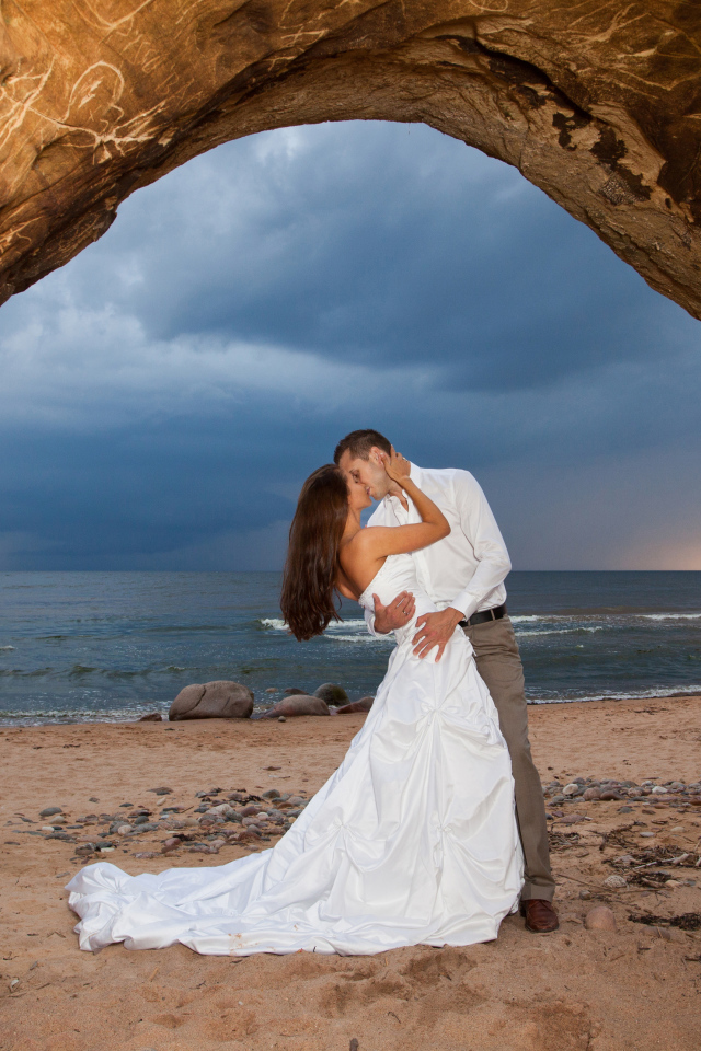 Поцелуй жениха и невесты на фоне моря