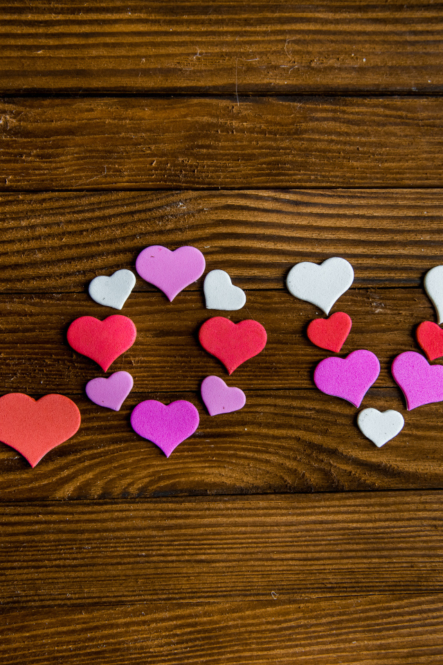 Надпись любовь из разноцветных сердец на деревянном столе