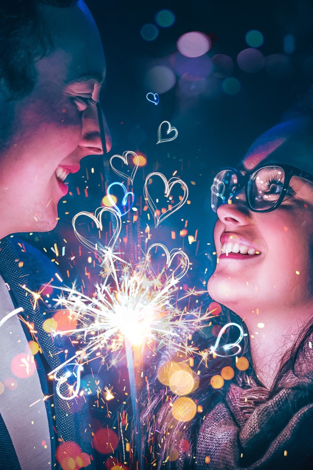 Влюбленные парень и девушка с бенгальским огнем в руке