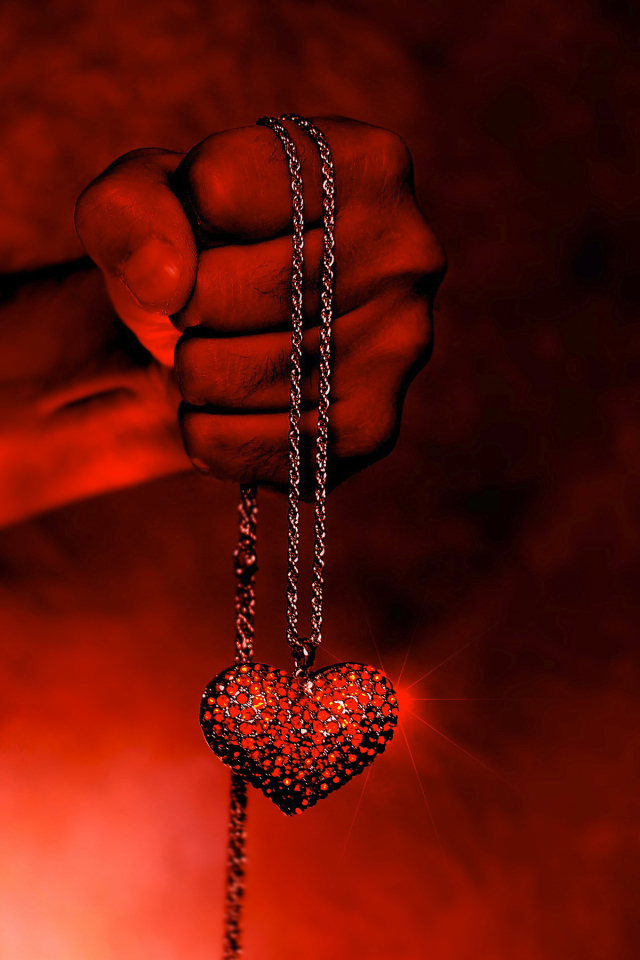 Кулон с сердцем на цепочке в мужской руке 