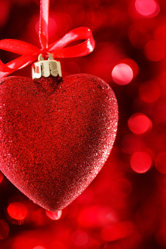 Красное большое блестящее сердце с лентой на красном фоне