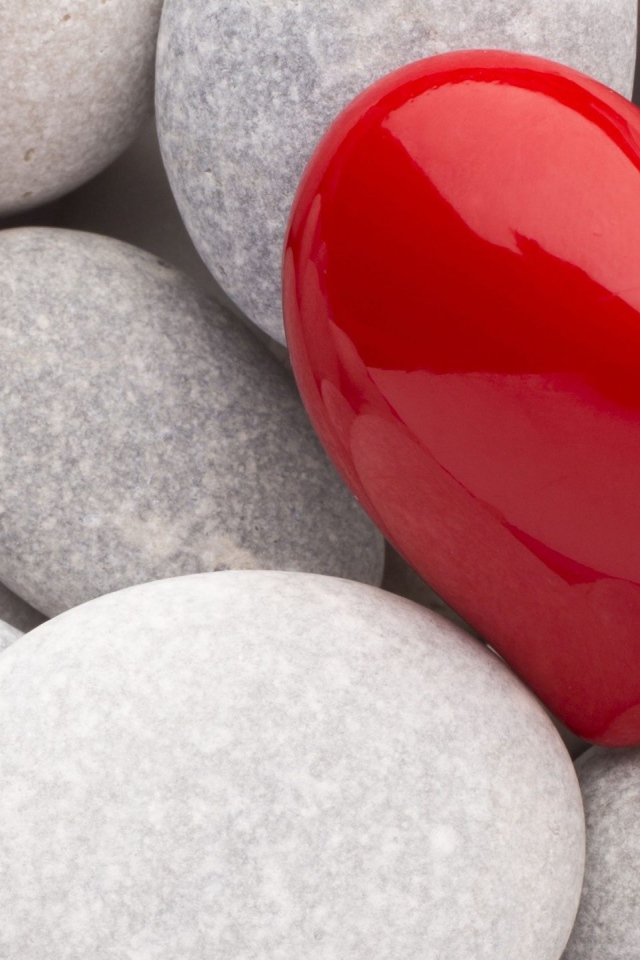 Red heart lies on gray stones