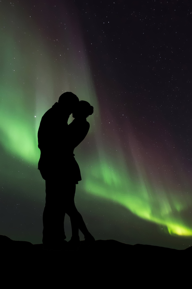 Силуэт влюбленной пары на фоне северного сияния 