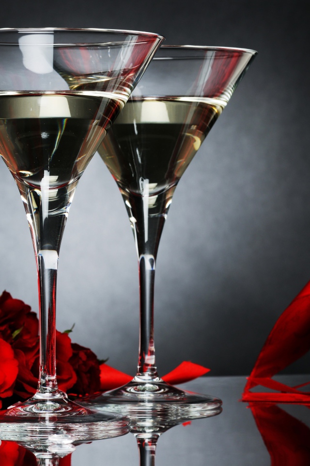 Два бокала с мартини, подарком и красными розами для любимой