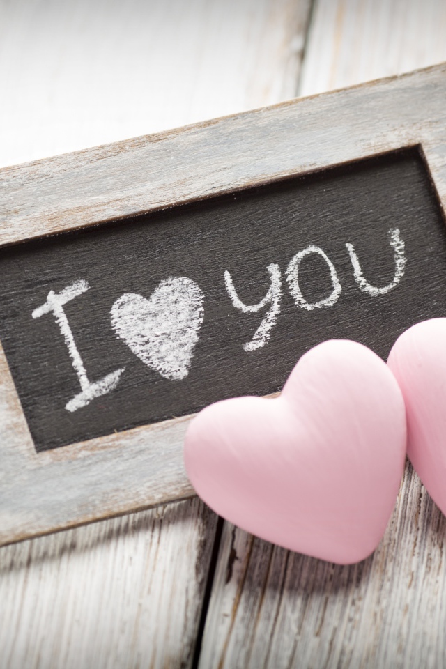 Два розовых сердца на столе с деревянной рамкой