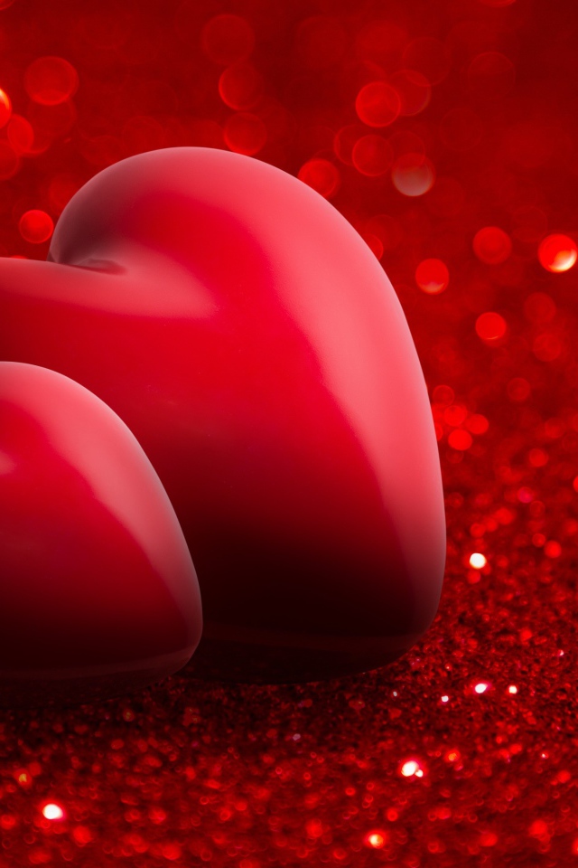 Два красных сердца на блестящем красном фоне