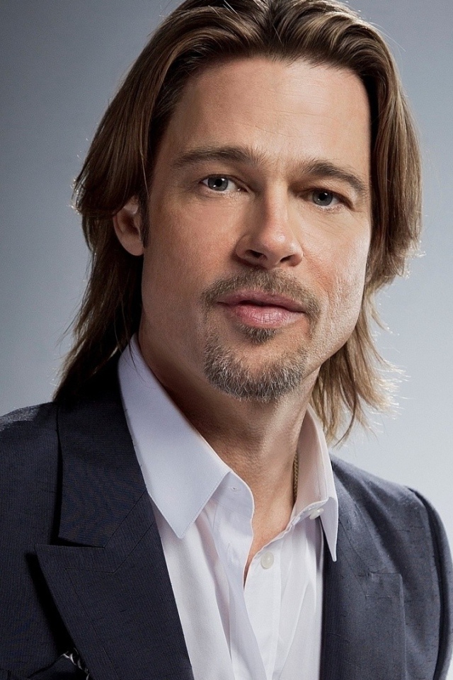 Актер Брэд Питт в костюме на сером фоне