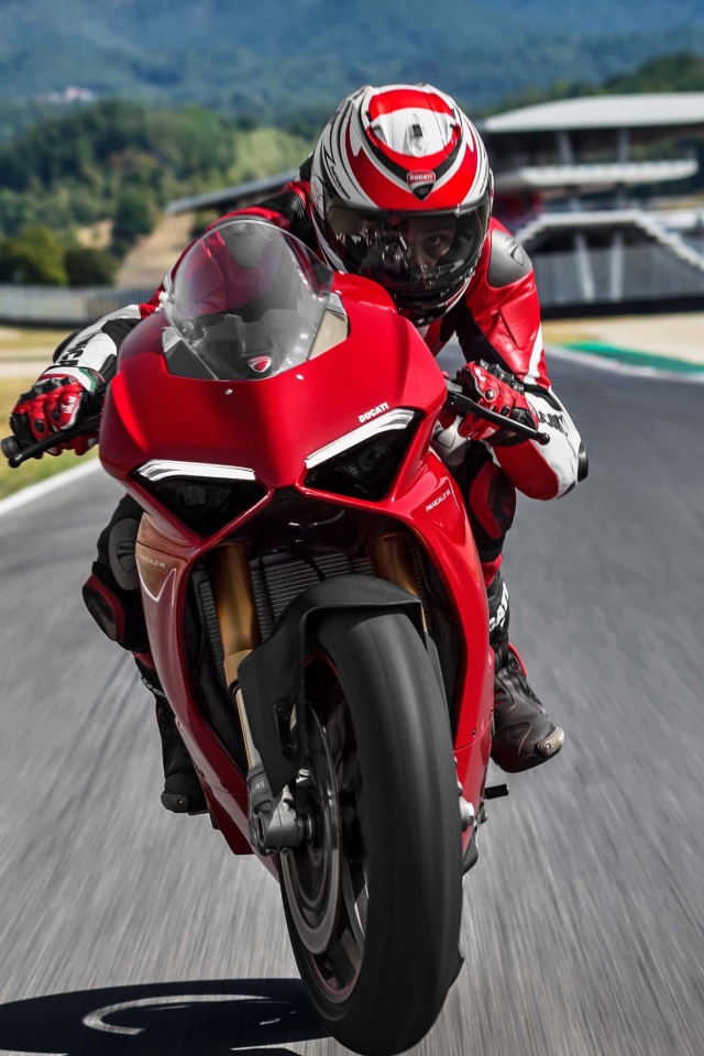 Красный мотоцикл  Ducati Panigale V4 S, 2018 на трассе с мотогонщиком