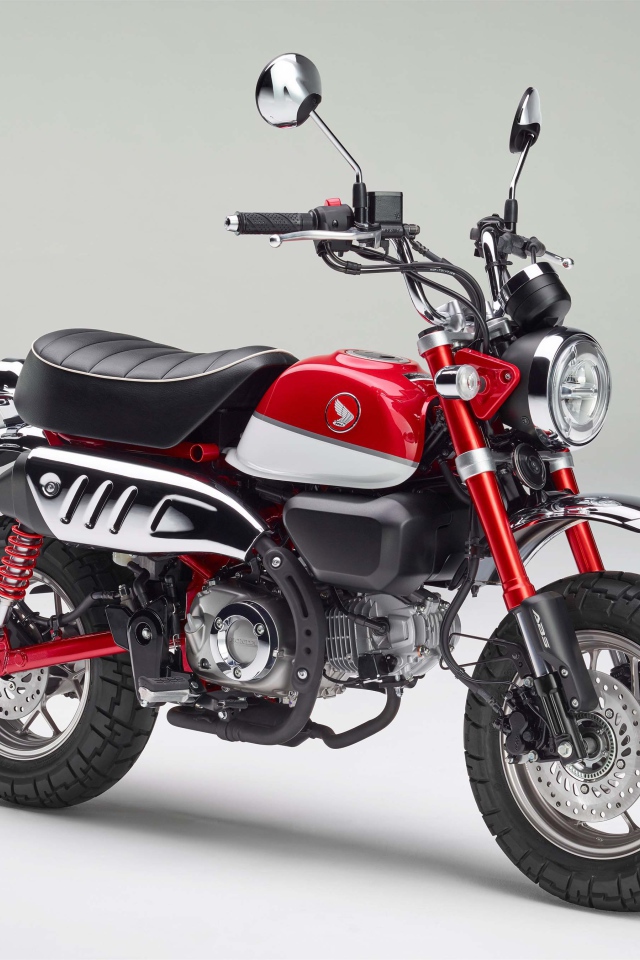 Красный мотоцикл Honda Monkey, 2018 года на сером фоне