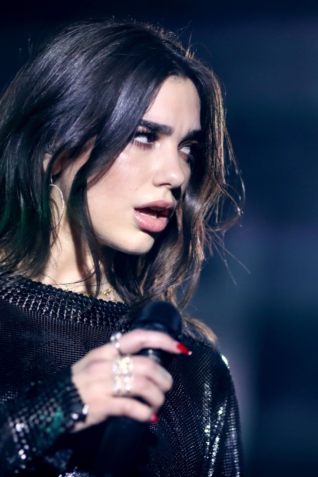 Британская певица Дуа Липа с микрофоном в руках