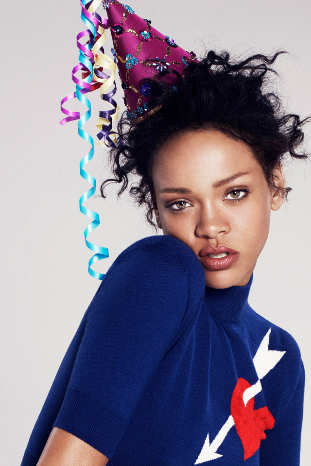 Певица Рианна в праздничном колпаке на сером фоне