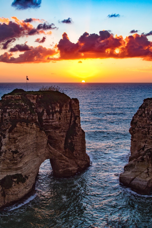 Арка скала в море на закате солнца