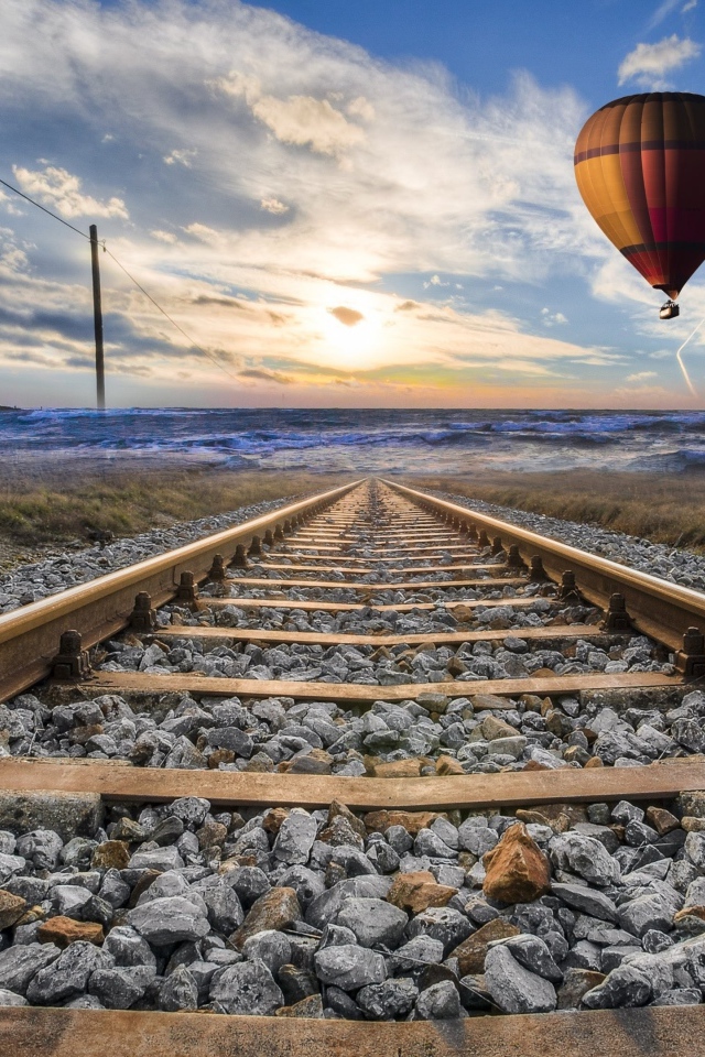 Воздушный шар в красивом голубом небе над железной дорогой