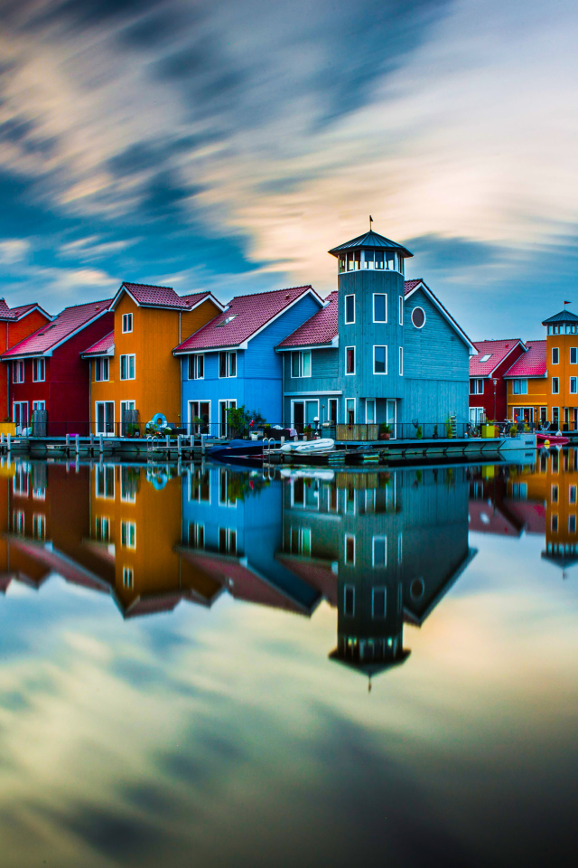 Красивые разноцветные дома отражаются в воде под красивым небом