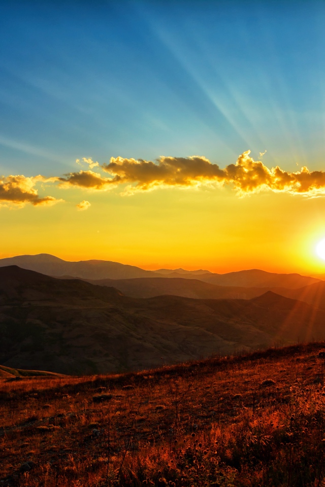 Красивый рассвет в небе над зелеными холмами