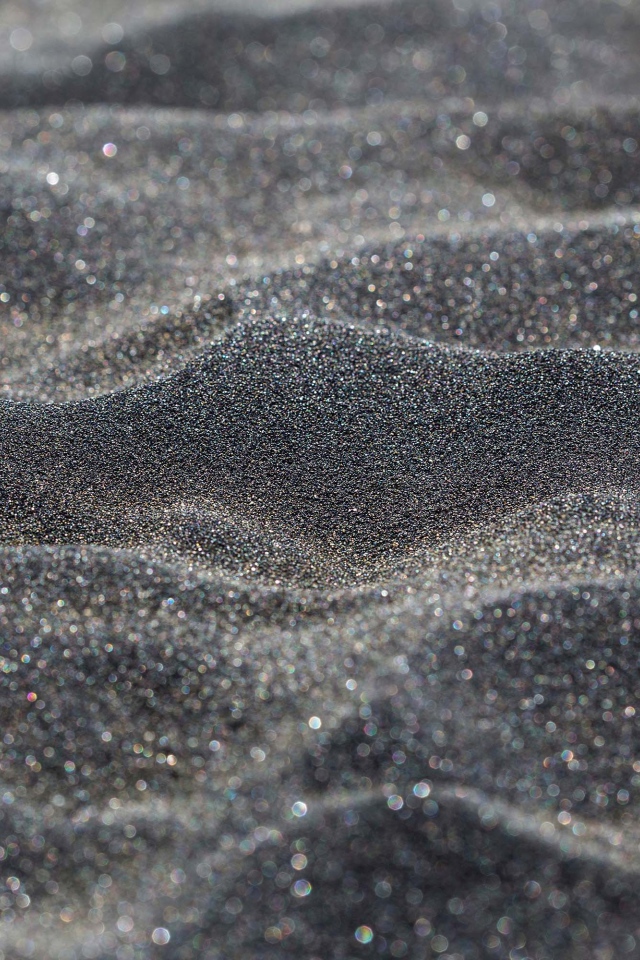 Блестящий черный песок крупным планом
