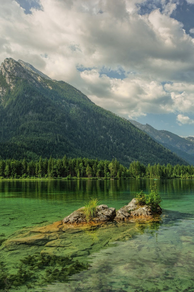 Покрытые хвойным лесом горы отражаются в озере