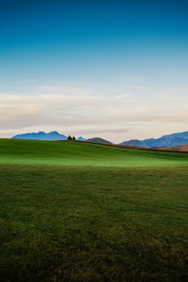 Зеленый луг на фоне красивого неба